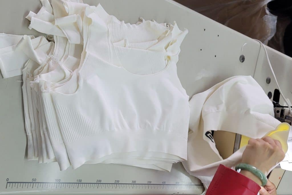 Manual quality control inspection for activewear garment sizing to ensure consistent fit.